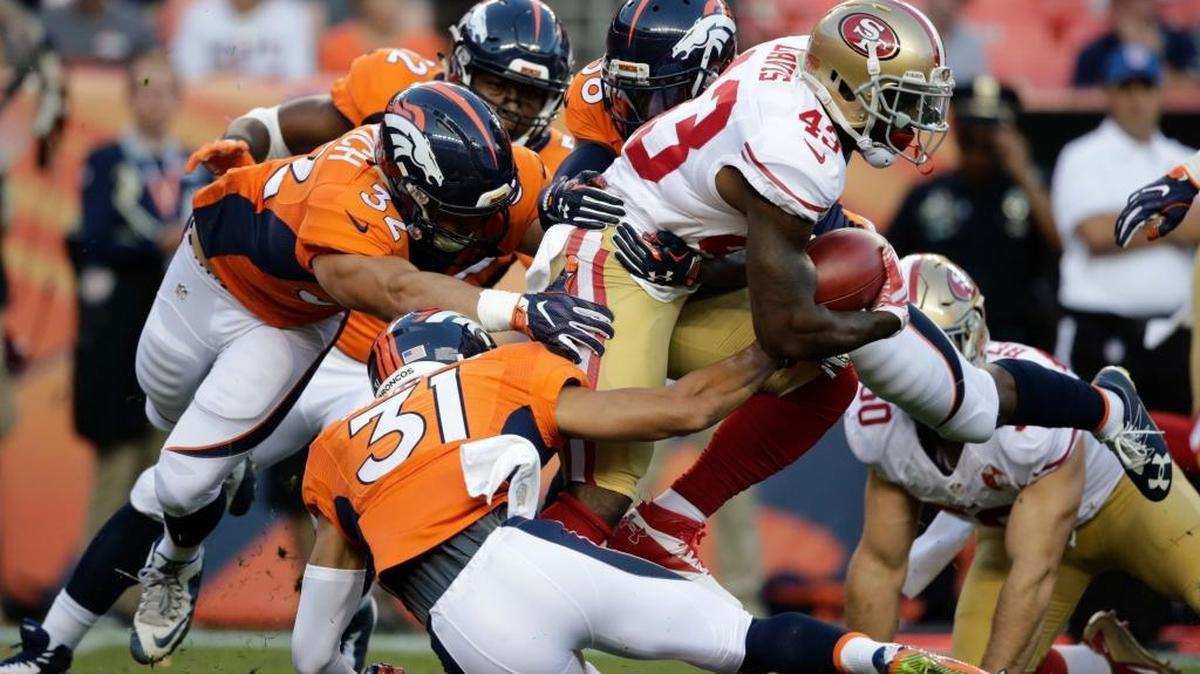 San Francisco 49ers' Chris Davis (43) is tackled by several Denver Broncos, including Justin Simmons (31) and Andy Janovich (32), during the first half of a preseason NFL football game, Saturday, Aug. 20, 2016, in Denver.
