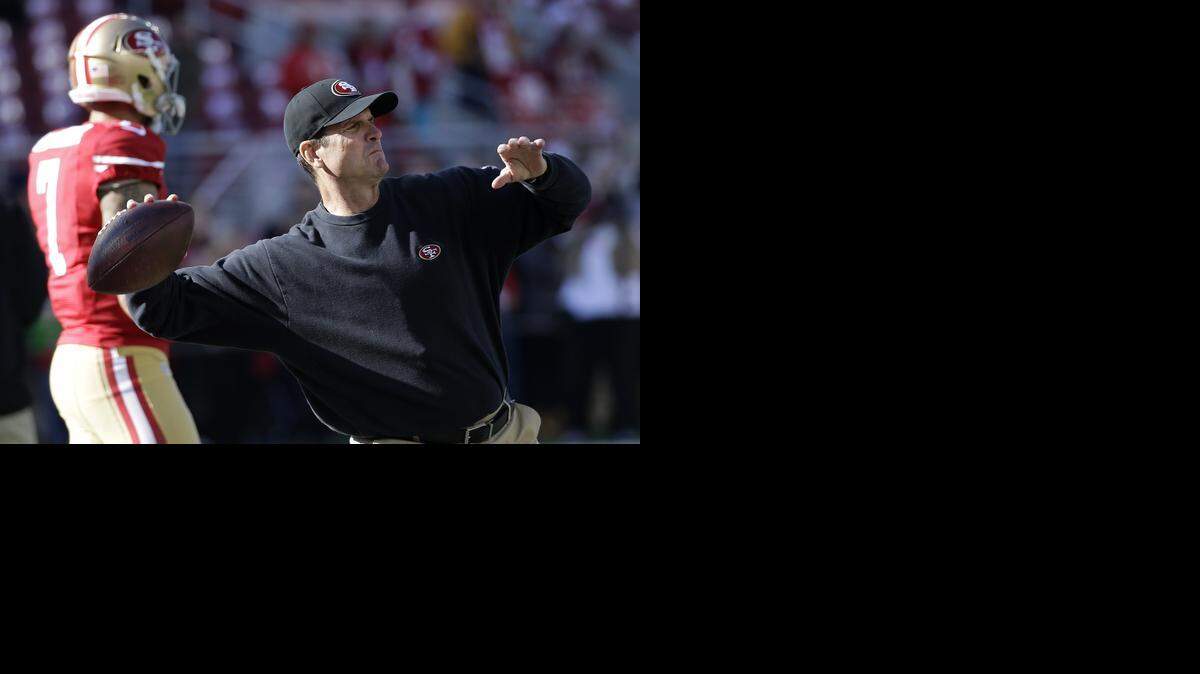 
San Francisco 49ers head coach Jim Harbaugh throws a pass in front of quarterback Colin Kaepernick before an NFL football game against the Arizona Cardinals in Santa Clara, Calif., Sunday, Dec. 28, 2014.
