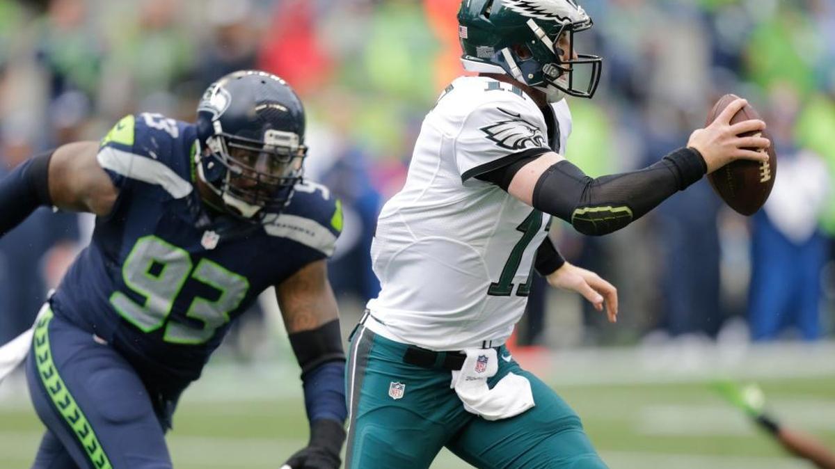 Philadelphia Eagles quarterback Carson Wentz, right, scrambles away from Seattle Seahawks defensive tackle Tony McDaniel (93) in the first half of an NFL football game, Sunday, Nov. 20, 2016, in Seattle.