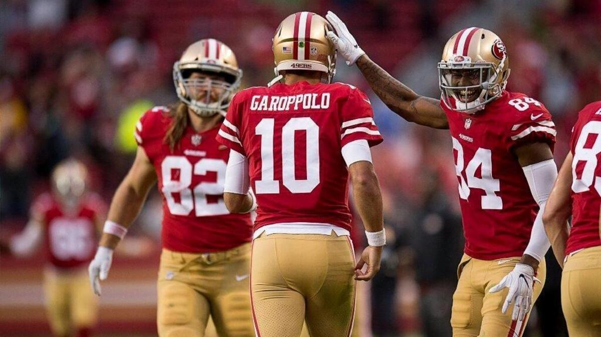 Quarterback Jimmy Garoppolo celebrates with teammates after throwing his first touchdown as a member of the San Francisco 49ers.