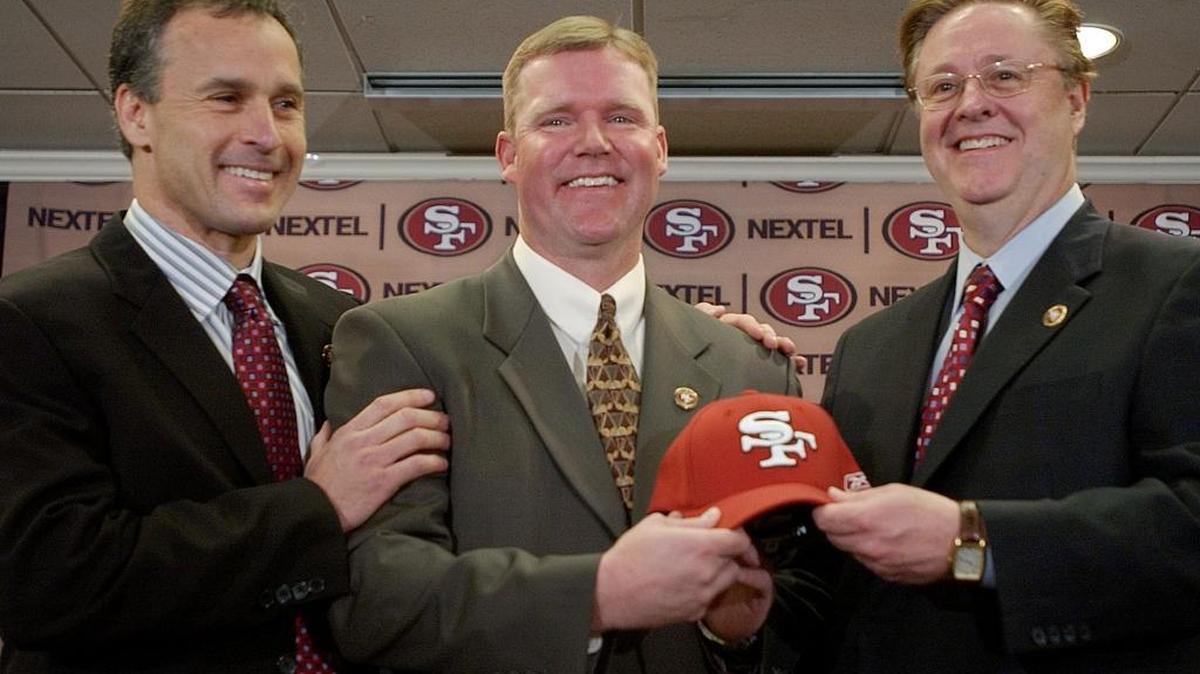 New San Francisco 49ers vice president of player personnel Scot McCloughan, center, smiles with new head coach Mike Nolan, left, and 49ers owner John York, right, during a news conference in Burlingame, Calif., Wednesday, Feb. 2, 2005.