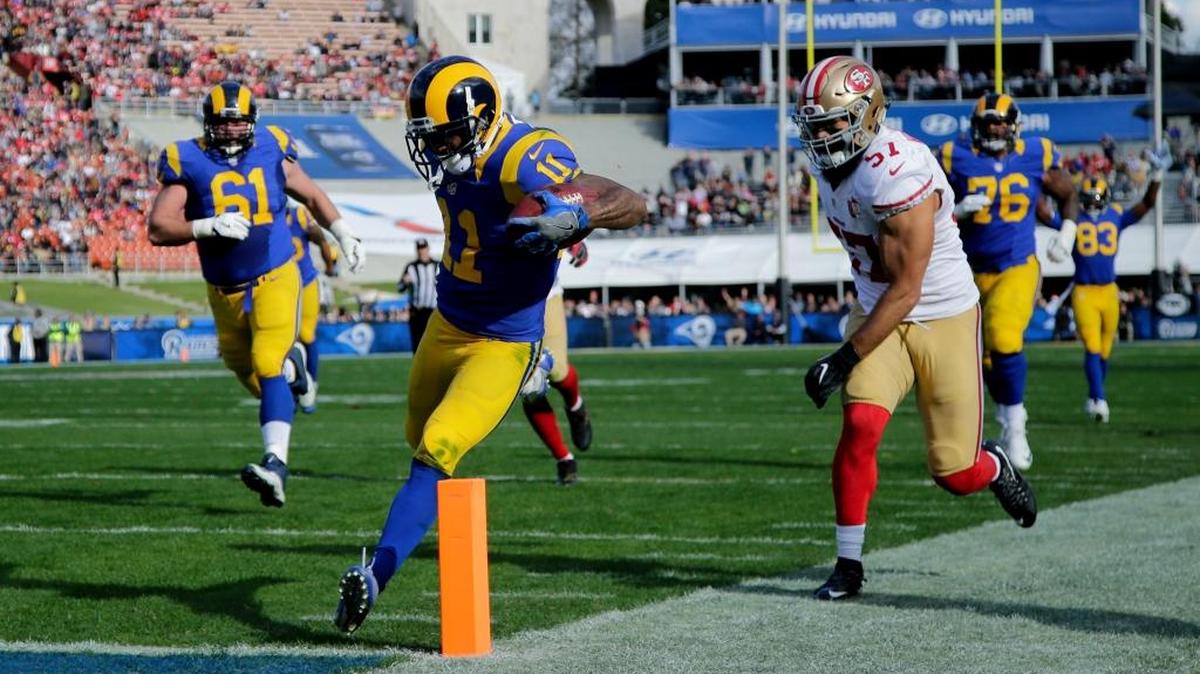 Los Angeles Rams wide receiver Tavon Austin scores as San Francisco 49ers inside linebacker Michael Wilhoite looks on during the first half of an NFL football game Saturday, Dec. 24, 2016, in Los Angeles.