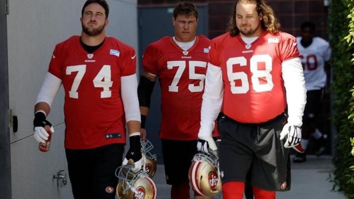Joe Staley (74) and Zane Beadles (68), walking with Collin Kelly, are among the big fellas competing for starting spots on the San Francisco 49ers offensive line.