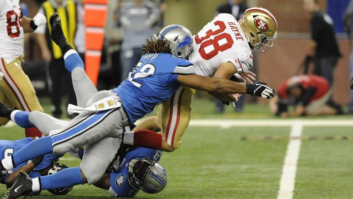San Francisco 49ers running back Jarryd Hayne is stopped by Detroit Lions defensive end Darryl Tapp (52) during the first half of an NFL football game, Sunday, Dec. 27, 2015, in Detroit.