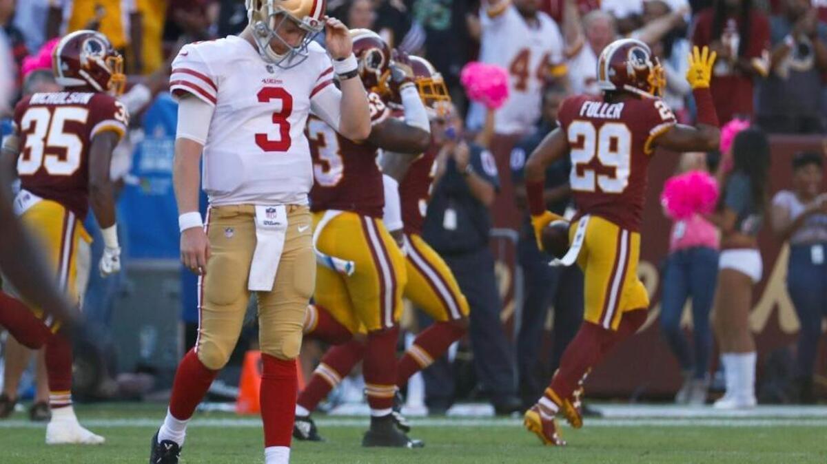 Quarterback C.J. Beathard (3) walks off the field as Washington Redskins cornerback Kendall Fuller (29) celebrates his interception that ended the game Sunday in Landover, Md. The Redskins defeated the 49ers 26-24.