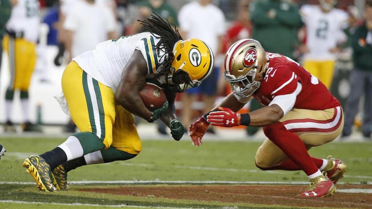 Green Bay Packers running back Eddie Lacy is stopped by San Francisco 49ers free safety Eric Reid, right, Friday, Aug. 26, 2016, in Santa Clara.