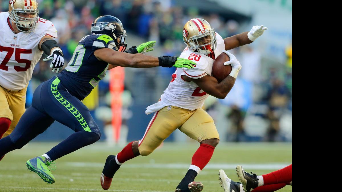 
San Francisco 49ers running back Carlos Hyde (28) tries to avoid a tackle by Seattle Seahawks outside linebacker K.J. Wright on Dec. 14, 2014, in Seattle. Hyde, who was placed on the Non-Football Injury list (NFI), dealt with a minor calf pull during spring drills but is not believed to have suffered an injury and likely won’t be on NFI very long. 

