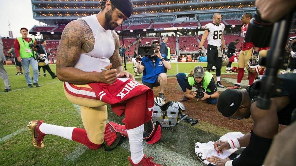 Colin Kaepernick signs his 49ers jersey after a game against the New Orleans Saints on Nov. 6, 2016, in Santa Clara. A young boy wearing Kaepernick’s jersey recently received a gift from two Washington Redskins players.