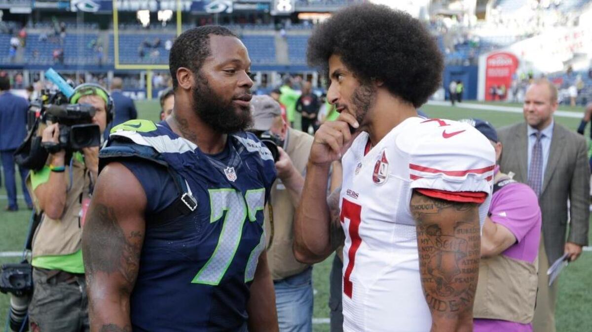 Seattle Seahawks defensive end Michael Bennett, left, talks with 49ers quarterback Colin Kaepernick following a game last season.