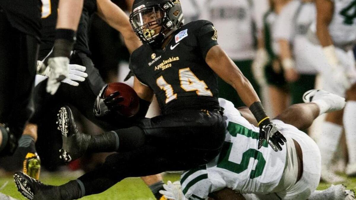 Appalachian State running back Marcus Cox (14) is pulled down by Ohio linebacker Jovon Johnson (51) in the Camellia Bowl NCAA college football game in Montgomery, Ala., Saturday, Dec. 19, 2015.