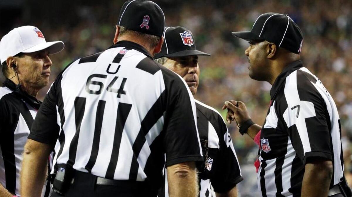 Officials, including side judge Keith Washington, right, discuss a play late in the fourth quarter of an NFL football game in Seattle, where a fumble by Detroit Lions wide receiver Calvin Johnson went out of the back of end zone and ruled a touchback. The failure to notice the Seattle Seahawks linebacker K.J. Wright clearly illegally batting the ball out of the end zone on purpose was one of several missed calls this season.
