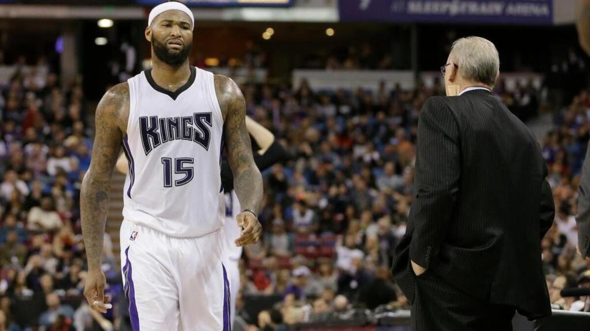 Kings center DeMarcus Cousins passes coach George Karl, right, as he walks to the bench Sunday, March 13, 2016, in Sacramento.