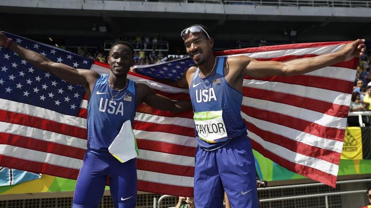 United States' silver medal winner Will Claye, left, and United States' gold medal winner Christian Taylor pose with U.S. flags after the men's triple jump final, during the athletics competitions in the Olympic stadium of the 2016 Summer Olympics in Rio de Janeiro, Brazil, Tuesday, Aug. 16, 2016.