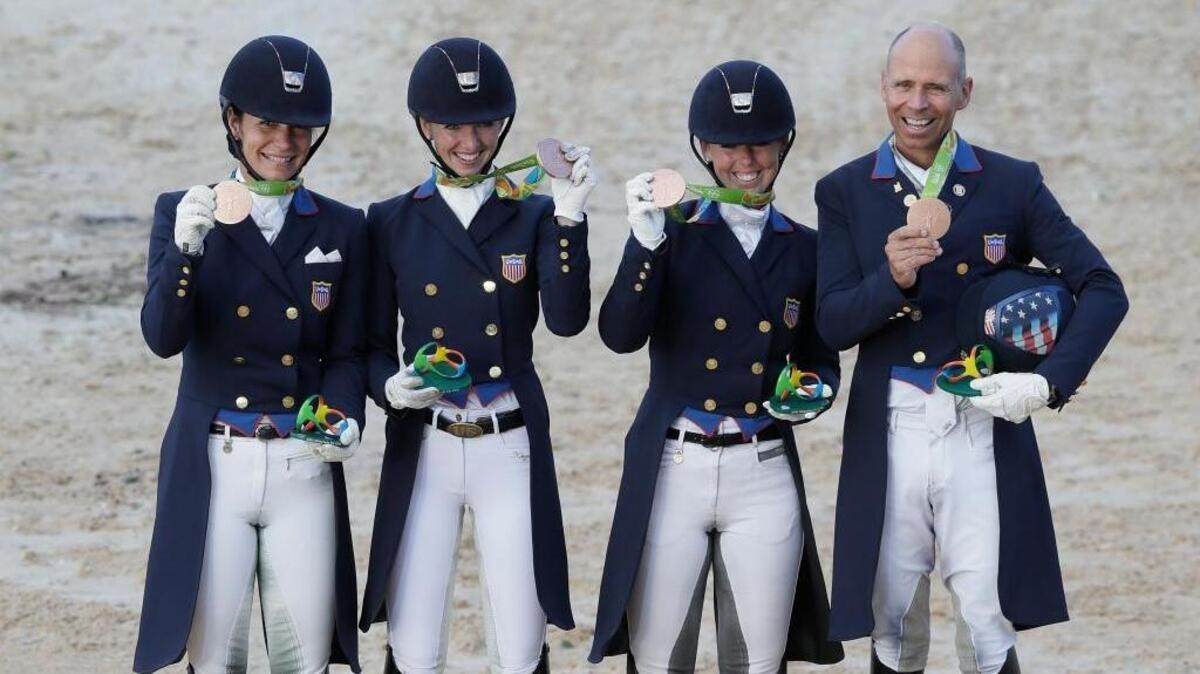 From left, the United States team of Allison M. Brock, Laura Graves, Kasey Perry-Glass and Steffen Peters hold up their bronze medals after the team dressage equestrian competition at the 2016 Summer Olympics in Rio de Janeiro, Brazil, Friday, Aug. 12, 2016.
