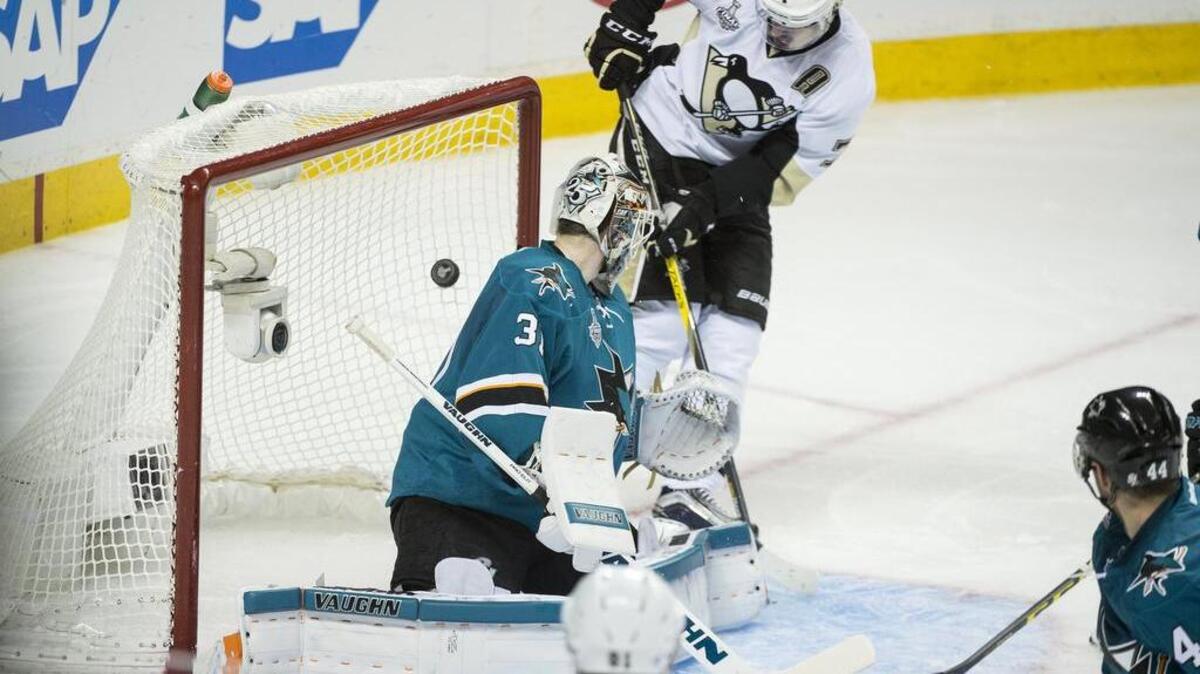 The Penguins’ Evgeni Malkin (71) chips the puck past Sharks goaltender Martin Jones for a goal that opened a 2-0 lead in the second period.