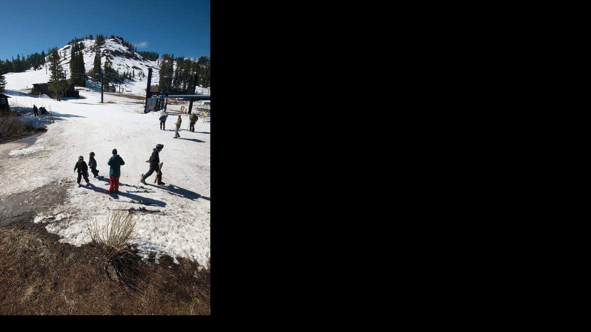 
Warm winter weather has melted snow, foreground, where skiers congregate Wednesday near a lodge below Mount Disney, background, at Sugar Bowl Ski Resort. Sugar Bowl will be closing down mountain operations this Sunday.
