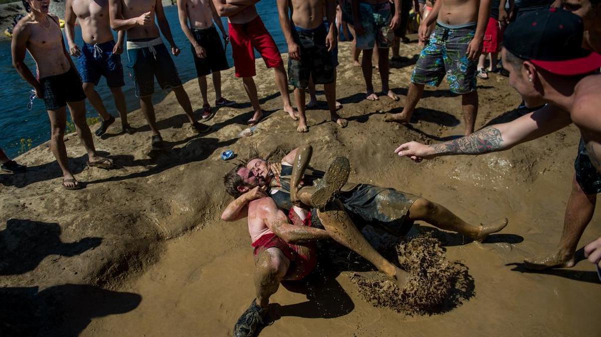 Mackenzie Wilson and Chris Paul mud-wrestle on “Gilligan’s Island,” a small spot of land across from Ancil Hoffman Park on Saturday, July 11, 2015, in Rancho Cordova, Calif. Sacramento County rangers plan to enforce an alcohol ban along the American River on Saturday in response to a plan by Rafting Gone Wild to hold one of their raucous rafting events.