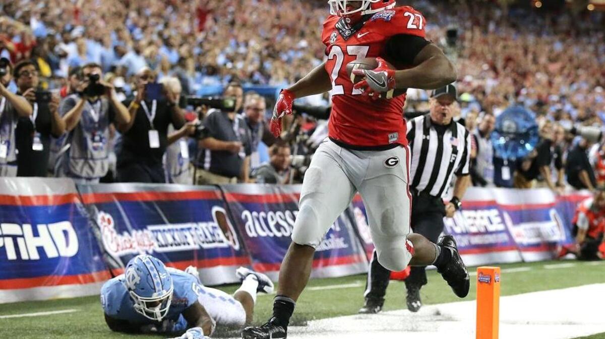 Georgia tailback Nick Chubb hits the end zone past North Carolina defender M.J. Stewart for a touchdown in an NCAA college football game in Atlanta on Saturday, Sept. 3, 2016.