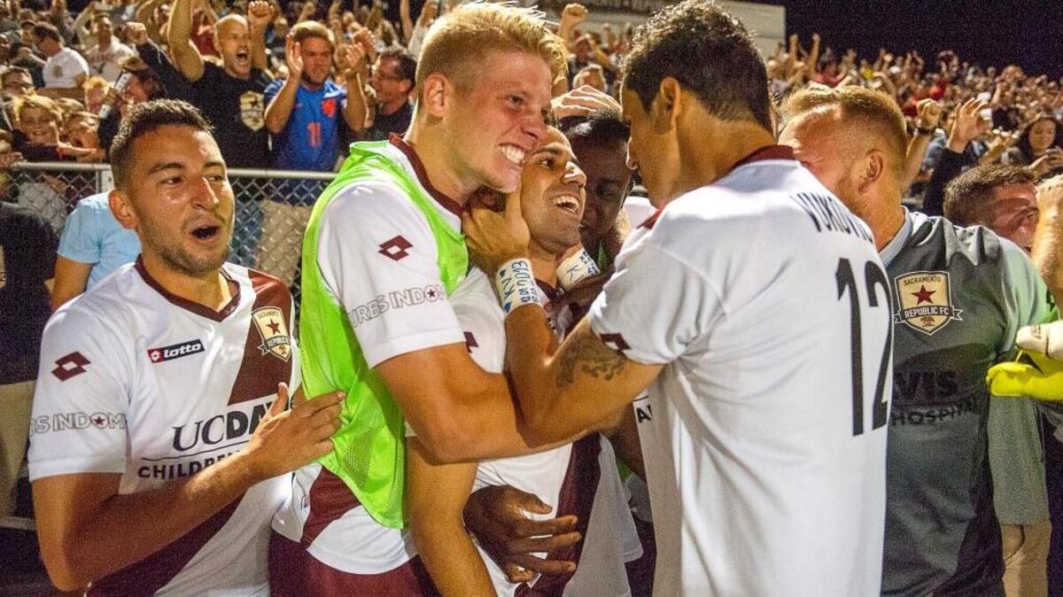 
Republic FC’s Rodrigo Lopez, at center, is surrounded by teammates on the sidelines as they celebrates his third goal on a penalty to go ahead 3-2 during the second half against LA Galaxy II in the second round of the USL playoffs at Bonney Field on Sept. 20, 2014. 
