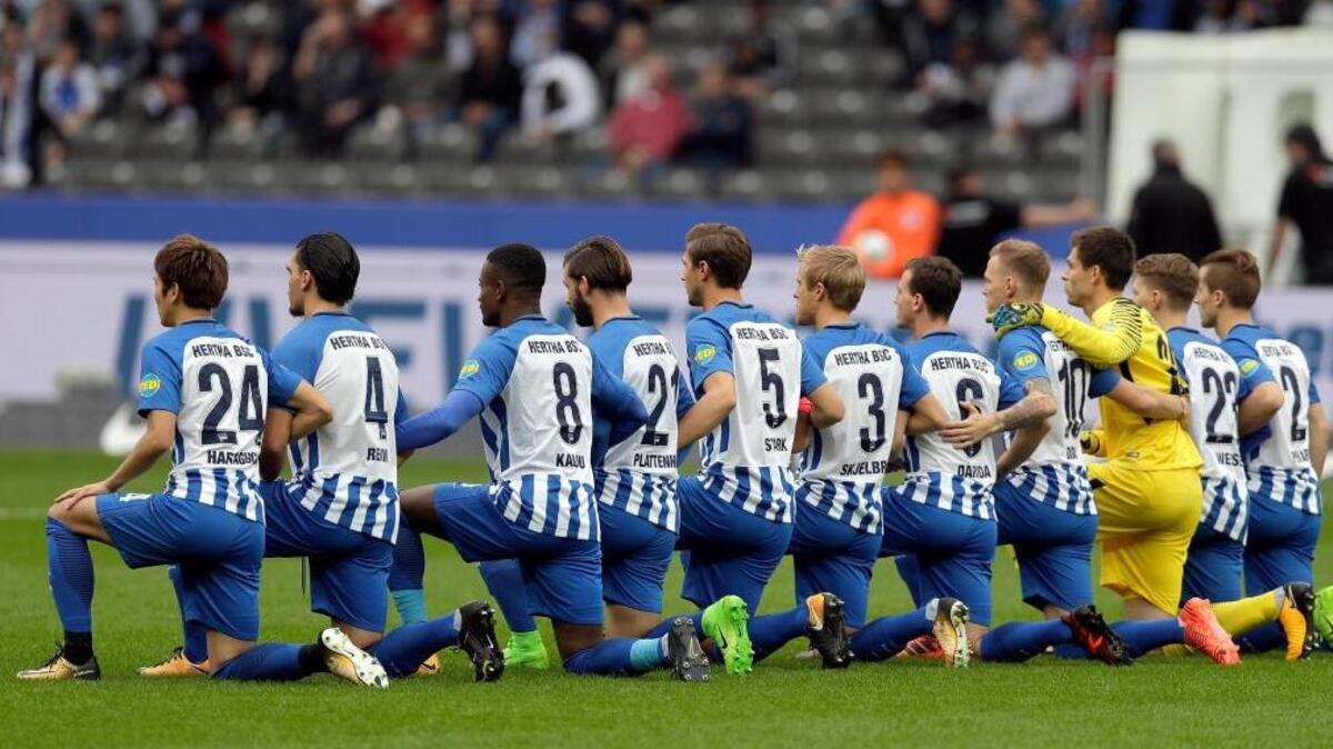 Players with German Bundesliga soccer club Hertha BSC take a knee before their home game against FC Schalke 04 on Saturday in Berlin.