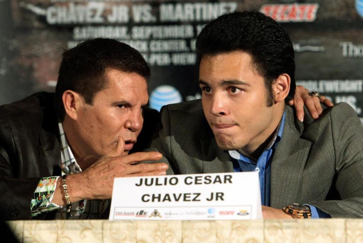 Julio Cesar Chavez Jr., right, talks with his father, legendary boxer Julio Cesar Chavez, at a news conference to promote a fight in 2012. Chavez is 50-3-1 for his career, but his father has much more impressive statistics.