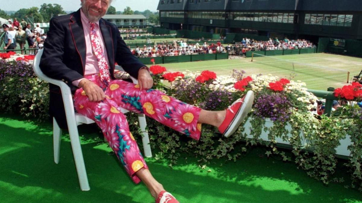 In this June 30, 1993 file photo, NBC tennis commentator Bud Collins displays a pair of his brightly colored signature trousers as he sits overlooking the courts at Wimbledon. Collins died Friday, March 4, 2016 at home in Brookline, Mass. He was 86.