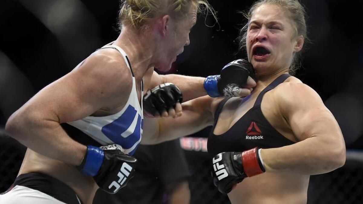 Holly Holm, left, punches Ronda Rousey during their UFC 193 bantamweight title fight in Melbourne, Australia, Sunday, Nov. 15, 2015. Holm pulled off a stunning upset victory over Rousey in the fight, knocking out the women's bantamweight champion in the second round with a powerful kick to the head Sunday.