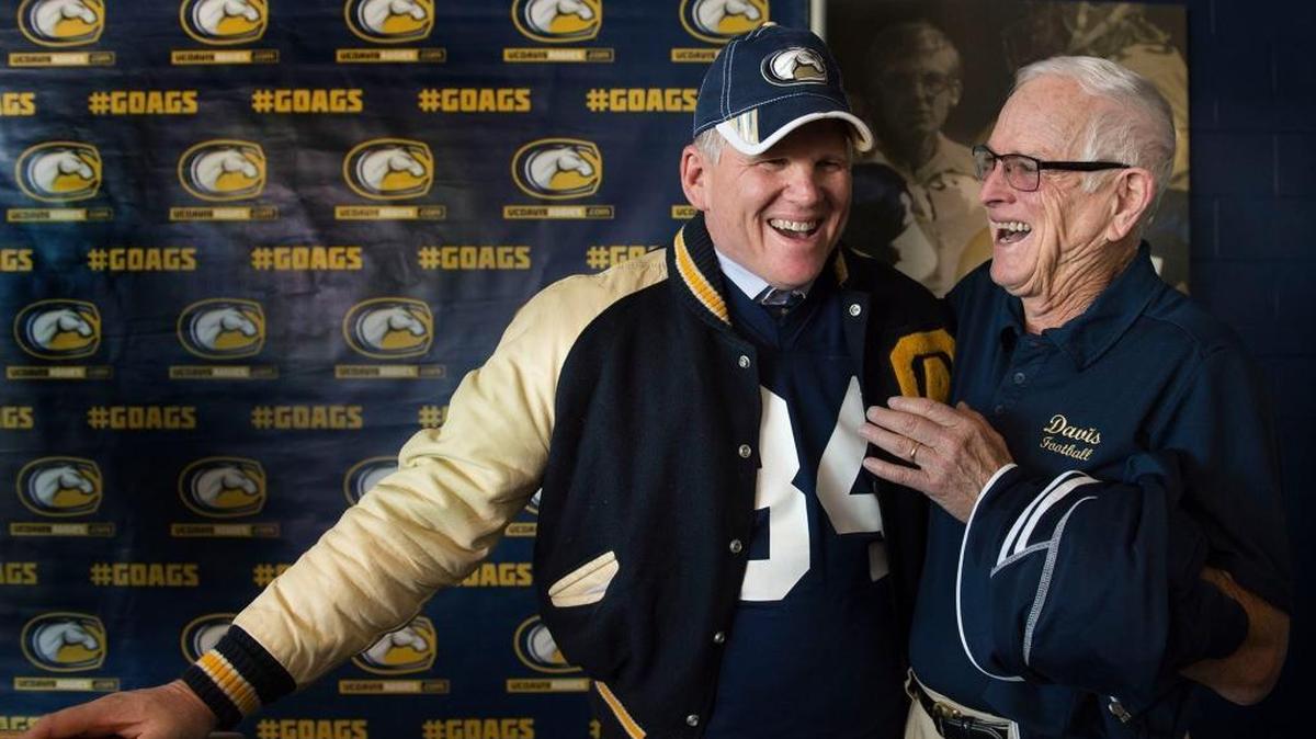 Former UC Davis football player and new Aggies head coach Dan Hawkins, who put on his old jersey and letterman jacket during today's press conference, talks to former Aggie head coach Bob Foster, right, at UC Davis on Tuesday, November 29, 2016 in Davis, Calif.