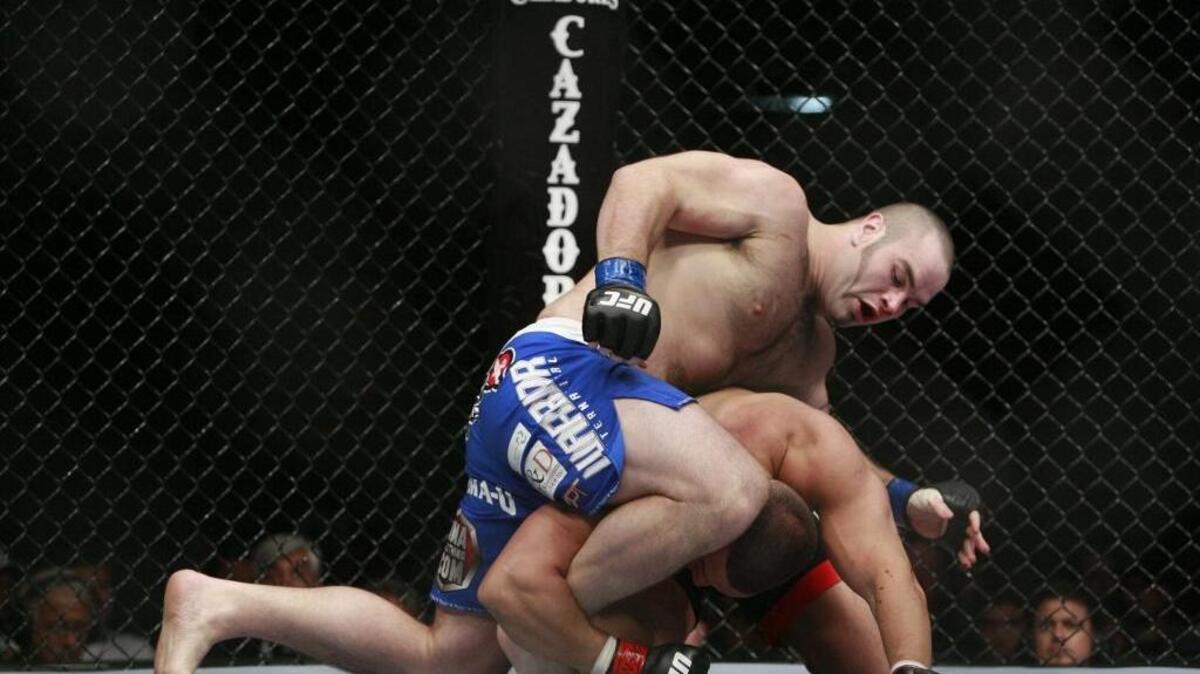 Tim Hague, top, fights Pat Barry during a UFC heavyweight fight in 2009. Hague died Sunday, two days after being knocked out in a boxing match. He was 34.